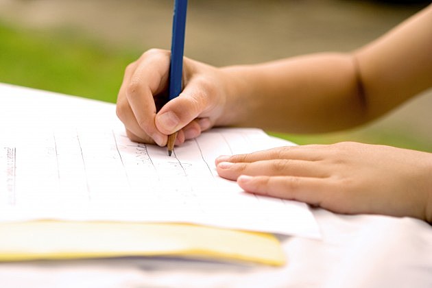 Young hands practising his writing skill, outdoors. Young hands practising his writing skill, outdoors.