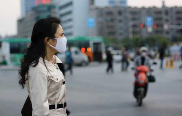 Woman wearing a face mask against pollution or disease Woman wearing a face mask against pollution or disease